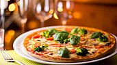 Frisch zubereitete Pizza mit frischen Kräutern und Gemüse im Familienhotel Am Rennsteig im Thüringer Wald.