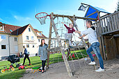 Familie mit spielt gemeinsam auf dem Außenspielplatz des Familienhotels Rhön Feeling.