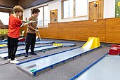 Zwei Kinder spielen Indoor Minigolf im Familienhotel Feldberger Hof