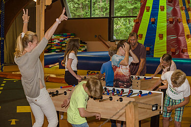 Familien spielen gemeinsam im Happy-Club Kicker und genißen Ihren Aufenthalt im Familienhotel Sonngastein in Bad Gastein.