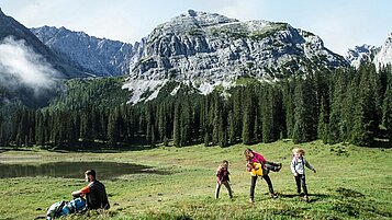 Eine Familie beim Wandern in den Tiroler Bergen rund um das Familienhotel Das Kaltschmid in Tirol.
