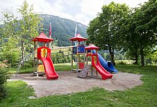 Großer Spielplatz mit Rutschen, Klettertürmen und Sandkasten im Familienhotel Bavaria im Allgäu.