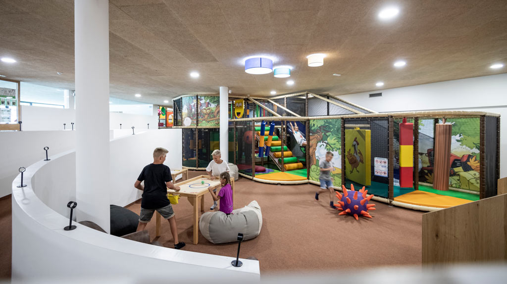 Teenager spielen in der Indoor-Spielhalle im Familienhotel Alphotel Tyrol Wellness & Family Resort in Südtirol.