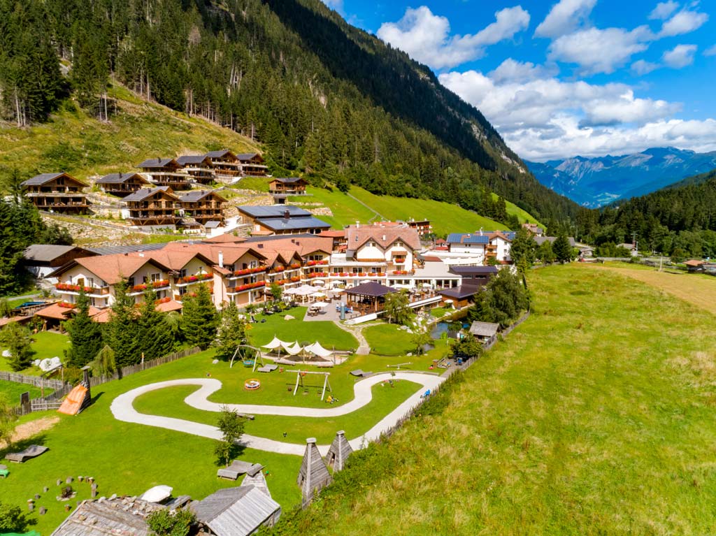 Luftaufnahme im Sommer vom Familienhotel Alphotel Tyrol Wellness & Family Resort in Südtirol.
