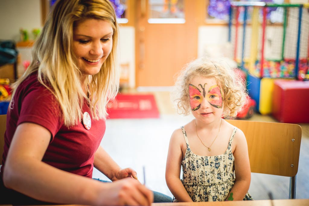 Mutter holt ihr Kleinkind von der liebevollen Kinderbetreuung im Landgut Furtherwirt in Tirol ab.