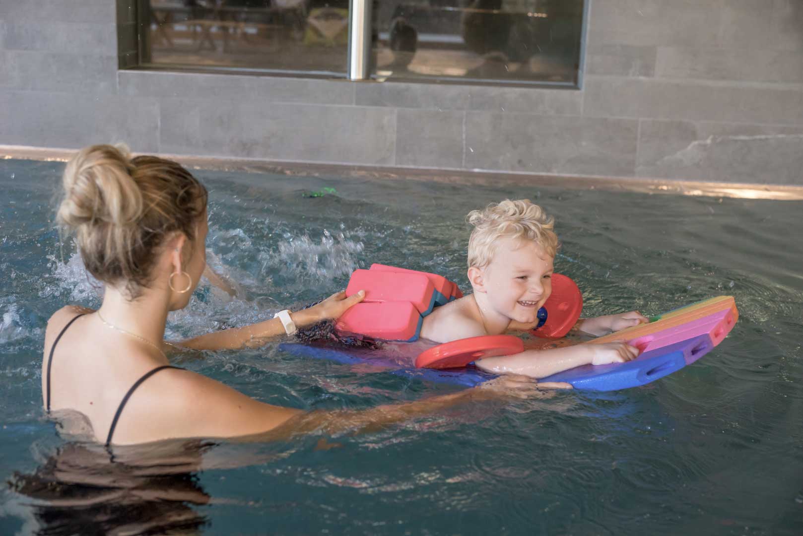 Mutter und Kind schwimmen gemeinsam im Pool des Familienhotels Gorfion
