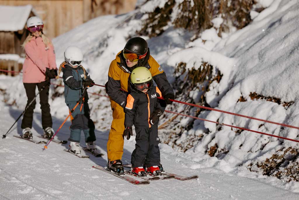 Eine Familie fährt mit dem Ski-Lift die Kinderhang hoch.