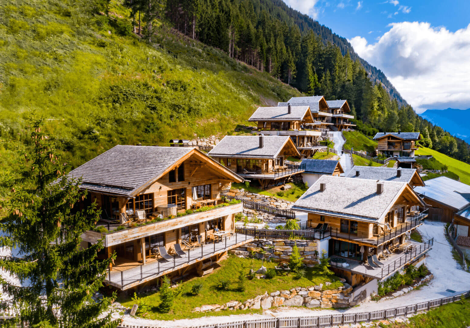 Außenansicht der Mons Silva Private Luxury Chalets in Südtirol. Die Chalets liegen am in der schönen Natur am Waldrand.