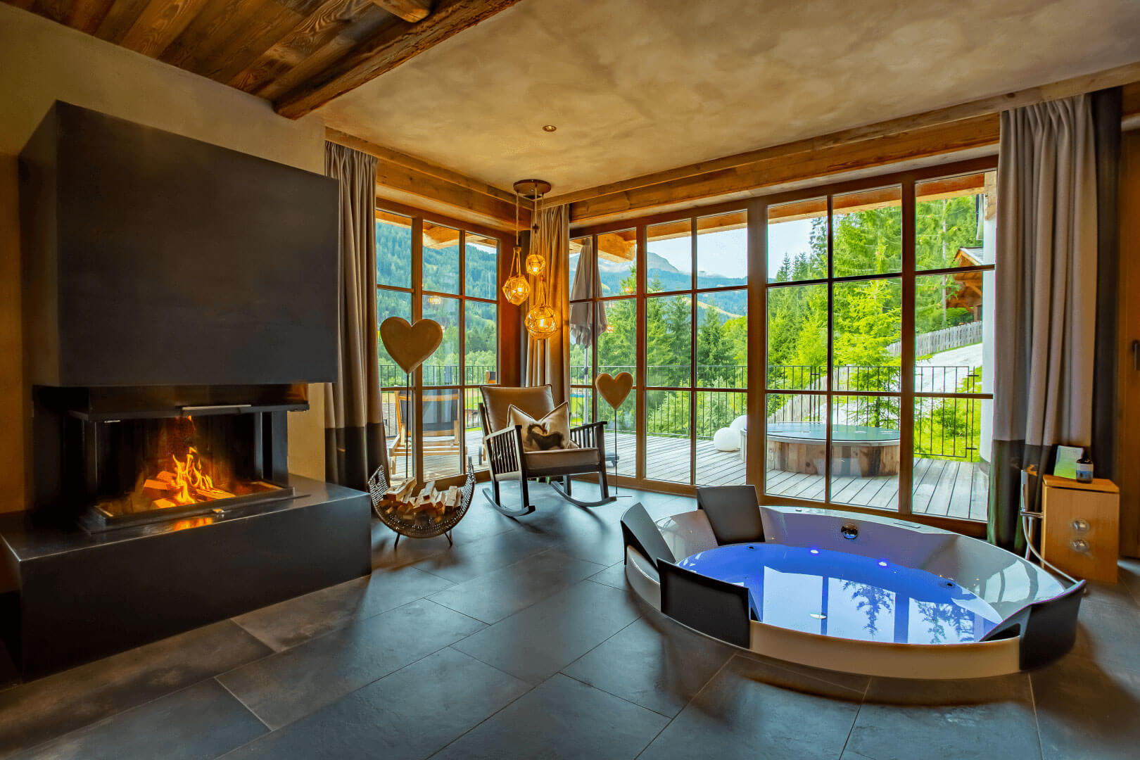 Wohnbereich mit eigenem Indoor Whirlpool und Hot Tub auf der Terrasse im Mons Silva Private Luxury Chalet.