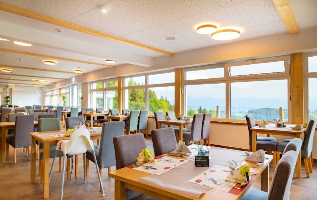 Restaurant mit Panoramafenstern und Kinderhochstühlen im Familienhotel Familien Resort Petschnighof in Kärnten.