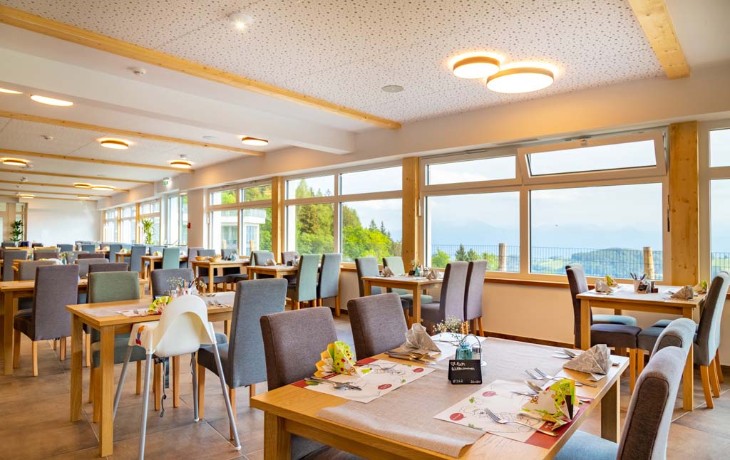 Restaurant mit Panoramafenstern und Kinderhochstühlen im Familienhotel Familien Resort Petschnighof in Kärnten.