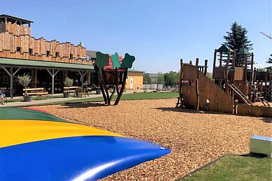 Großer Spielplatz im Außenbereich mit Kletterburg und Trampolin im Familienhotel Elldus Resort im Erzgebirge 