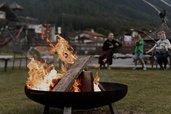 Ein gemütliches Lagerfeuer brennt vor beeindruckender Bergkulisse beim Familienhotel Tirolerhof