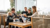Familie stößt auf der gemütlichen Terrasse des Familienhotels Alpengasthof Hochegger mit Getränken an