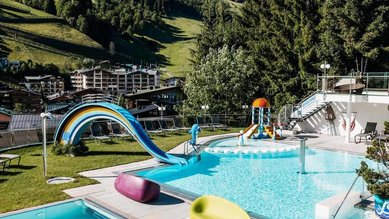 Outdoor-Pool mit Wasserspielen und Bergblick im Wellness- & Familienhotel Egger im Salzburger Land.