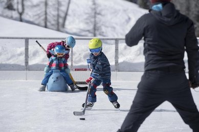Kinder beim Eislaufen auf einem Eisplatz in Liechtenstein.