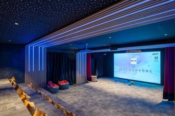 Familienkino mit interaktiver Leinwand, Sitzkissen und stimmungsvoller Beleuchtung im Familienhotel Huber in Südtirol