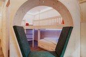 Ein liebevoll gestaltetes Familienzimmer im Familienhotel Tirolerhof mit gemütlichem Hochbett, Sitznische und viel Holz