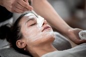 Frau genießt eine entspannende Gesichtsbehandlung mit Maske im Familienhotel Alpenhof Dolomit Family.
