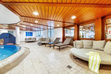 Großzügiger Ruhebereich mit Liegen, Sofas und Holzdecke im Wellnessbereich des Hotel Engel im Schwarzwald