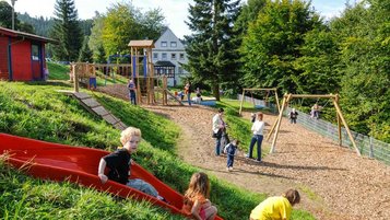 Kinder spielen auf dem großen Outdoor-Spielplatz im Familienhotel Mein Krug im Fichtelgebirge