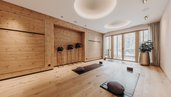 Moderner Yoga- und Entspannungsraum im Habachklause Familien Bauernhof Resort mit warmem Holzdesign und Blick auf die verschneite Natur