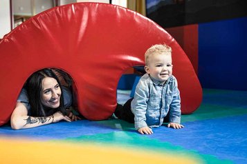 Kind krabbelt im Happy Club eines Familienhotel über Matten