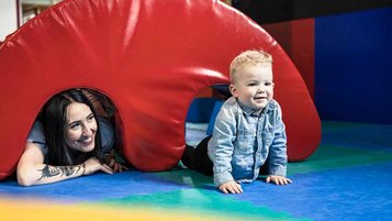 Kind krabbelt im Happy Club eines Familienhotel über Matten