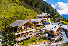 Außenansicht der Mons Silva Private Luxury Chalets in Südtirol. Die Chalets liegen am in der schönen Natur am Waldrand.