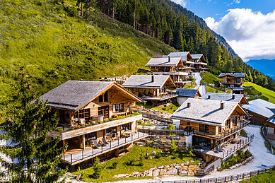Außenansicht der Mons Silva Private Luxury Chalets in Südtirol. Die Chalets liegen am in der schönen Natur am Waldrand.