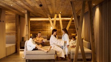 Familie entspannt im Ruhebereich des Familien-Wellnessbereichs im Familienhotel Alpenhotel Kindl.