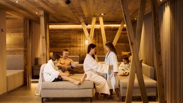 Familie entspannt im Ruhebereich des Familien-Wellnessbereichs im Familienhotel Alpenhotel Kindl.