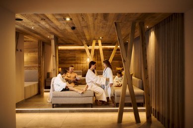 Familie entspannt im Ruhebereich des Familien-Wellnessbereichs im Familienhotel Alpenhotel Kindl.