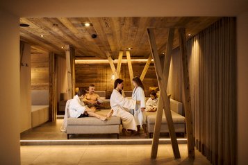 Familie entspannt im Ruhebereich des Familien-Wellnessbereichs im Familienhotel Alpenhotel Kindl.