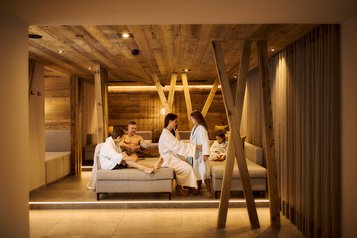 Familie entspannt im Ruhebereich des Familien-Wellnessbereichs im Familienhotel Alpenhotel Kindl.