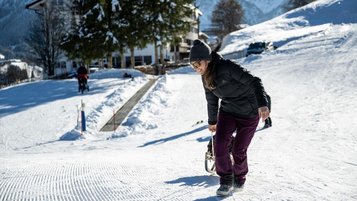 Mutter und Tochter beim Schlittenfahren im Familienurlaub im Alphotel.