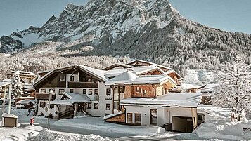 Das Familienhotel Tirolerhof in der Tiroler Zugspitzarena umgeben von einer weißen Winterlandschaft.