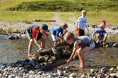 Die Kinder bauen ein Damm im Familienhotel Sonne Bezau Vorarlberg.