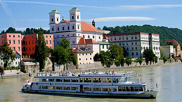 Ein Ausflugsboot auf der Donau vor der historischen Altstadt Passaus.