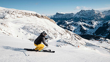 Ein Skifahrer bei der Abfahrt. Die Berge in Südtirol eignen sich für den perfekten Familienurlaub im Winter.