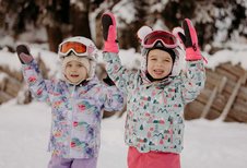 Zwei Mädchen die sich auf Ski fahren freuen.