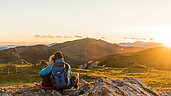 Ein Paar genießt die Aussicht von weit oben. Der Berg in Kaernten blickt auf seine Natur in der Umgebung.