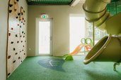 Der Indoor-Spielbereich im Familienhotel Friedrichshof begeistert mit Rutsche und Kletterwand.