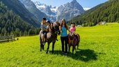 Kinder beim Reiten in der Natur im Familienurlaub im Familienhotel Bella Vista in Südtirol.