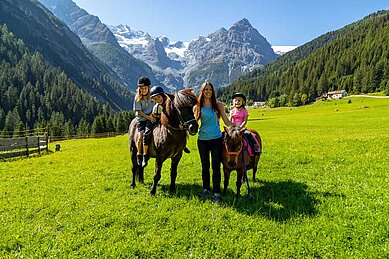 Kinder beim Reiten in der Natur im Familienurlaub im Familienhotel Bella Vista in Südtirol.