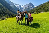 Kinder beim Reiten in der Natur im Familienurlaub im Familienhotel Bella Vista in Südtirol.