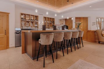 Stilvolle Kristall Bar mit gemütlichen Hochstühlen und moderner Ausstattung im Familienhotel Habachklause.