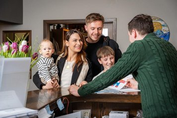 Familie checkt im Familienhotel Alpengasthof Hochegger in Kaernten ein.