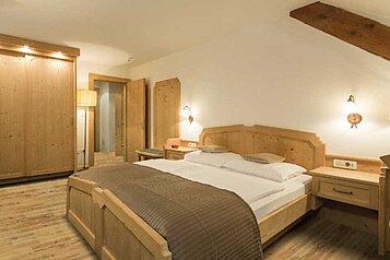 Familiensuite mit Doppelbett und großem Kleiderschrank im Familienhotel Bella Vista in Südtirol.