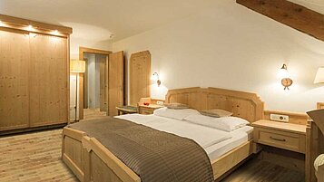 Familiensuite mit Doppelbett und großem Kleiderschrank im Familienhotel Bella Vista in Südtirol.